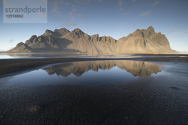 Pfützen am schwarzen Sandstrand mit dem Berg Vestrahorn im Hintergrund  Island