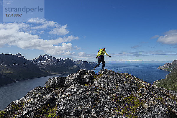 RÃ?ckansicht einer Wanderin auf dem Gipfel des Riven mitÂ OyfjordÂ im Hintergrund  Â Senja  Â Troms  Norwegen