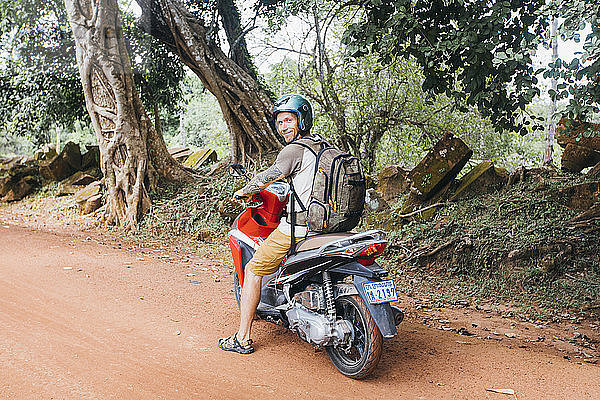 Ein Tourist auf einem Motorrad schaut in die Kamera  Siem Reap  Kambodscha