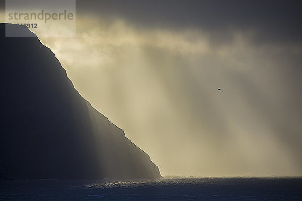 Schöne Naturlandschaft mit Silhouette der Küstenklippe bei Sonnenuntergang  Gasadalur  Färöer Inseln