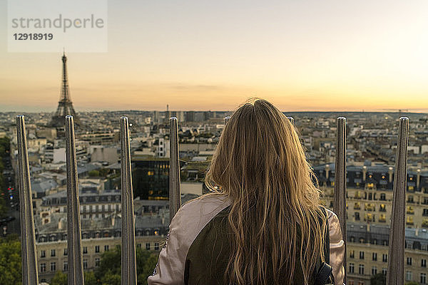 Rückansicht einer alleinstehenden Frau mit Blick auf Paris bei Sonnenuntergang vom Triumphbogen  Frankreich