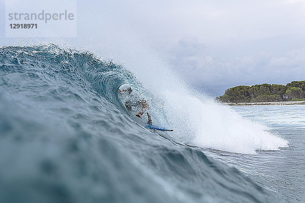 Männlicher Surfer  bedeckt mit Spritzwasser beim Wellenreiten  Male  Malediven