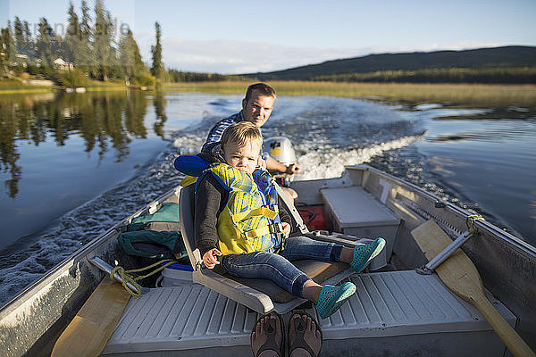 Blick auf Vater und Sohn  die gemeinsam Zeit auf einem Motorboot auf einem See verbringen  Kamloops  British Columbia  Kanada
