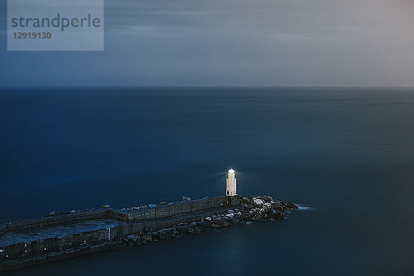Ruhige Meereslandschaft mit einsamen Leuchtturm und Pier in der Abenddämmerung  Camogli  Ligurien  Italien