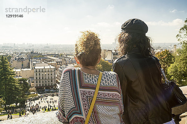 Rückansicht von zwei Touristinnen mit Blick auf die Aussicht auf Paris von der Basilique Du Sacre Coeur  Montmartre  Paris  Frankreich