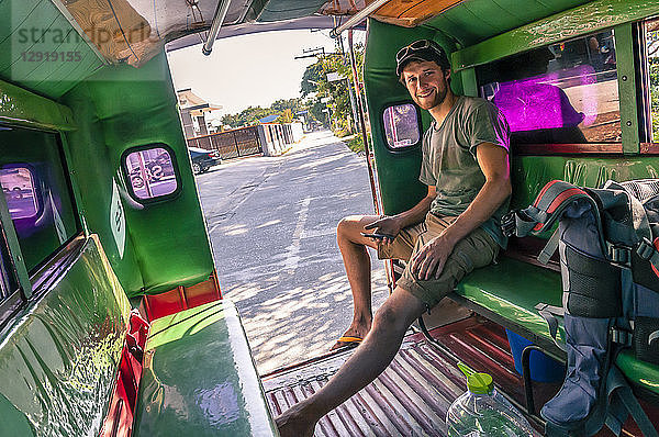 LÃ?chelnder junger Mann  der in einer Motor-Rikscha sitzt und in die Kamera schaut  Â ChiangÂ Mai  Thailand