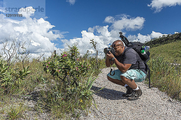 Junger erwachsener Fotograf beim Fotografieren typischer Cerrado-Pflanzen in der Chapada dos Veadeiros  Goias  Zentralbrasilien
