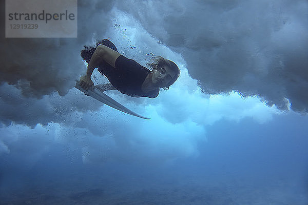 Unterwasseransicht eines männlichen Surfers  der beim Tauchen im Meer in die Kamera schaut  Male  Malediven