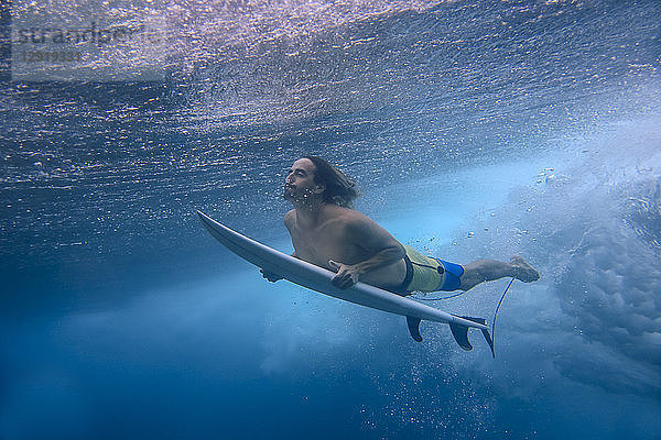 Unterwasseransicht eines männlichen Surfers beim Tauchen im Meer  Male  Malediven