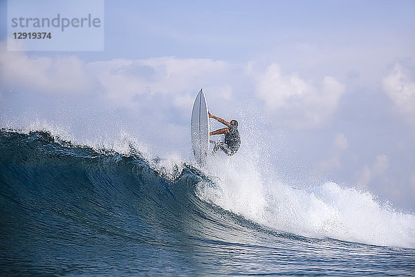 Male-Surfer reitet auf einer Welle gegen die Wolken  Male  Malediven