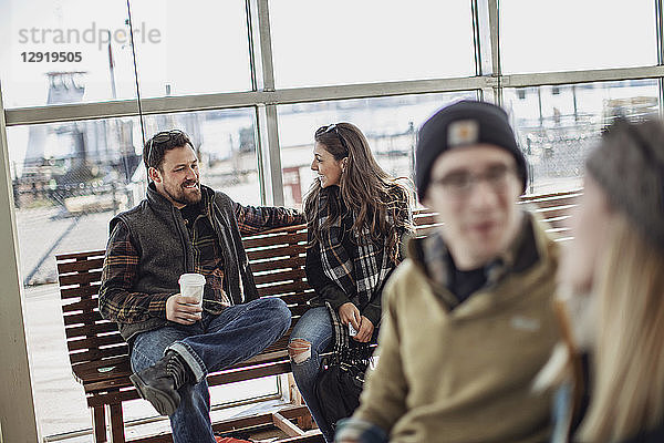 Vier erwachsene Freunde sitzen und unterhalten sich beim Warten am Fährterminal  Portland  Maine  USA