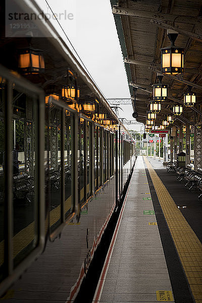 Wartender Zug am Bahnhof  beleuchtet von leuchtenden Laternen  Arashiyama  Kyoto  Japan