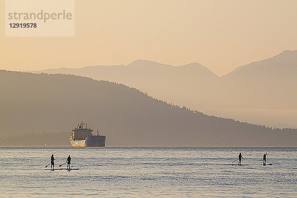 Gruppe von vier Personen beim Paddeln im Meer bei Sonnenuntergang  Vancouver  British Columbia  Kanada