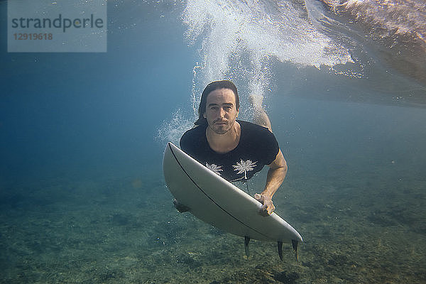 Männlicher Surfer schaut beim Tauchen im Meer in die Kamera  Male  Malediven