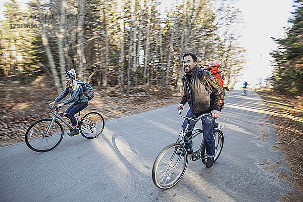 Zwei Freunde fahren gemeinsam auf Fahrrädern die Landstraße hinunter  Peaks Island  Maine  USA