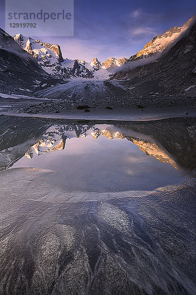 Sonnenaufgang gespiegelt in einem Teich am Forno-Gletscher  Forno-Tal  Maloja-Pass  Engadin  Graubünden  Schweiz  Europa