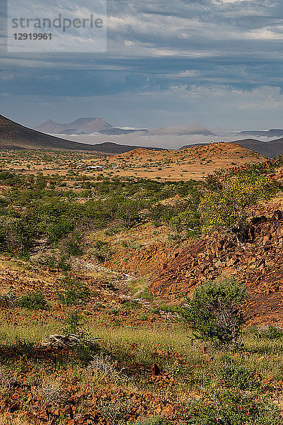 Farbenfrohe Felsenlandschaft hoch oben in den Bergen  mit Bergcamp im Hintergrund  Etendeka  Namibia