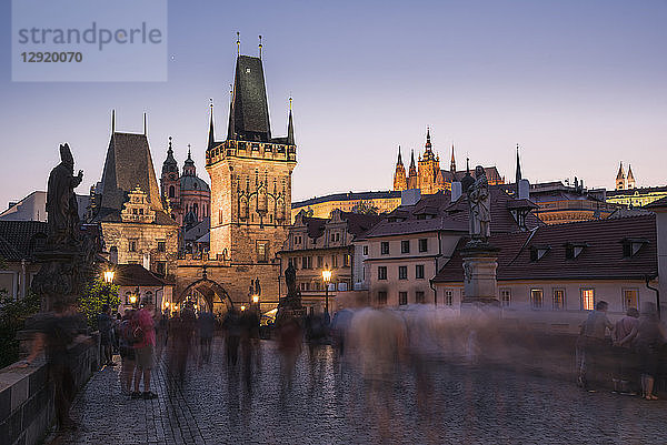 Karlsbrücke  Kleiner Turm und Prager Burg bei Nacht mit verschwommenen Fußgängern  UNESCO-Weltkulturerbe  Prag  Tschechische Republik  Europa