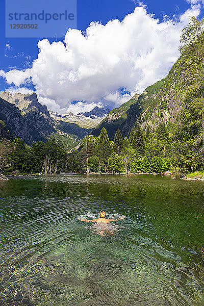 Ein Mädchen schwimmt in einem klaren Bergsee  Val di Mello (Mello-Tal)  Valmasino  Valtellina  Lombardei  Italien  Europa