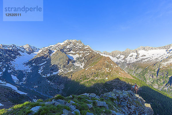 Ein Wanderer betrachtet den Berg Disgrazia von oben  Chiareggio-Tal  Valmalenco  Valtellina  Lombardei  Italien  Europa