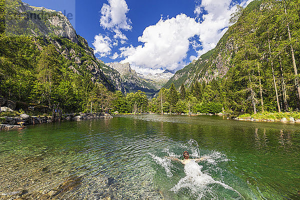 Ein Junge schwimmt in einem klaren Bergsee  Val di Mello (Mello-Tal)  Valmasino  Valtellina  Lombardei  Italien  Europa