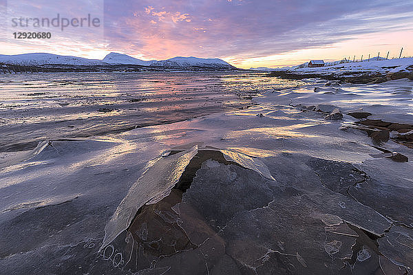 Sonnenuntergang auf mit Eis bedeckten Felsen  Troms  Norwegen  Skandinavien
