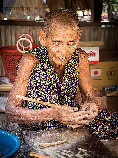 Alte Frau beim Räuchern  Dorfhaus in der Nähe von Siem Reap  Kambodscha  Indochina  Südostasien  Asien