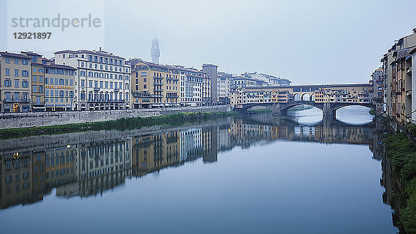Die Ponte Vecchio am Arno an einem nebligen Morgen mit dem in Nebel gehüllten Palazzo Vecchio  Florenz  UNESCO-Weltkulturerbe  Toskana  Italien