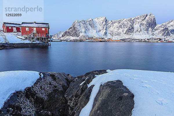 Traditionelle Fischerhütten (Rorbu) auf dem eisigen Meer  Reine-Bucht  Lofoten  Nordland  Norwegen
