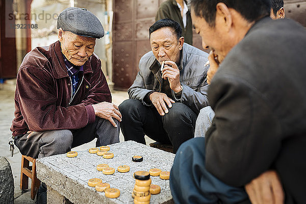 Männer spielen das traditionelle Spiel Xiangqi (chinesisches Schach)  Dali  Provinz Yunnan  China