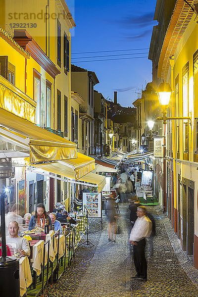 Blick auf Cafés in einer gepflasterten Straße in der Altstadt in der Abenddämmerung  Funchal  Madeira  Portugal