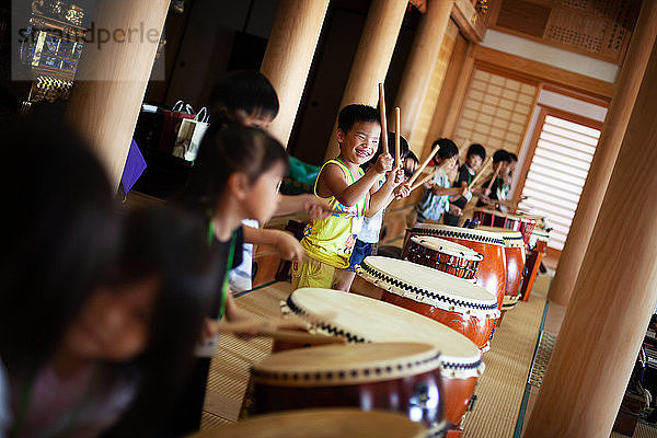 Gruppe von Kindern  die in einem Tempel die Trommeln spielen  ein traditioneller Satz Trommeln.