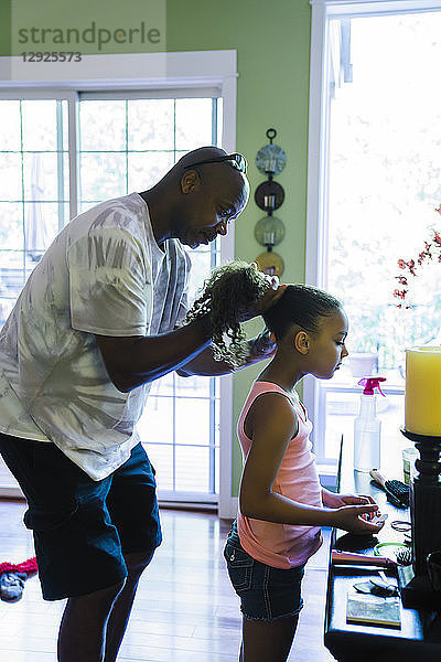 Vater repariert die Haare der Tochter