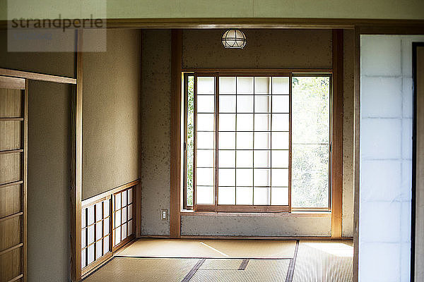 Innenansicht eines traditionellen japanischen Hauses mit Tatami-Matten und undurchsichtigen Schiebetüren.