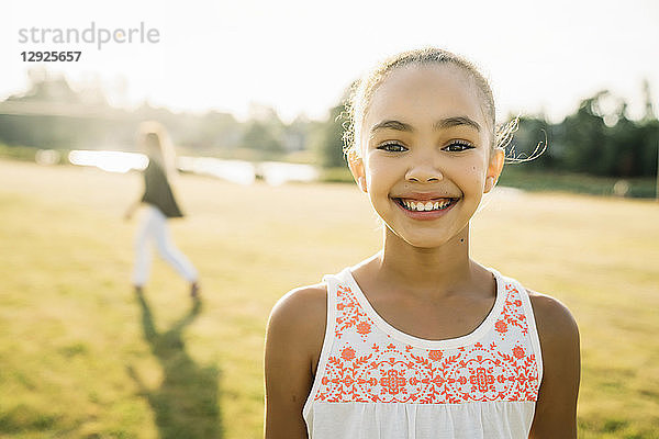 Porträt eines lächelnden Mädchens draussen im Park