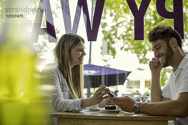 Ehepaar benutzt Smartphone in einem Café