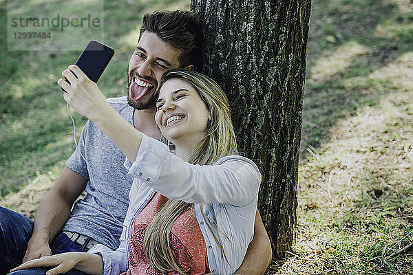 Junges Paar hört Musik und macht ein Selfie mit einem Smartphone