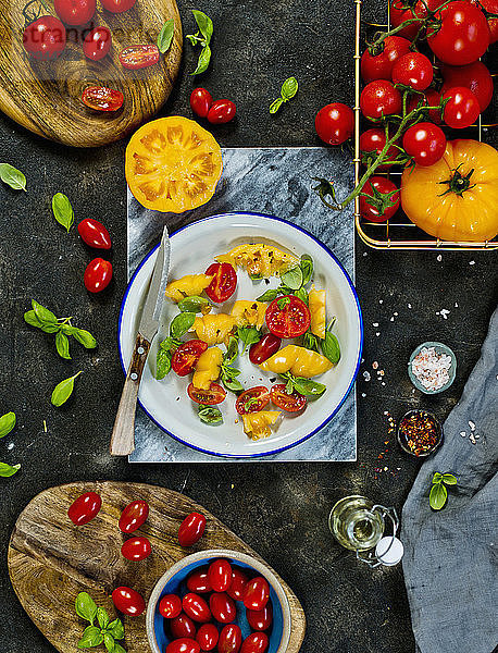 Ein Salat aus gelben und roten Tomaten mit Basilikum