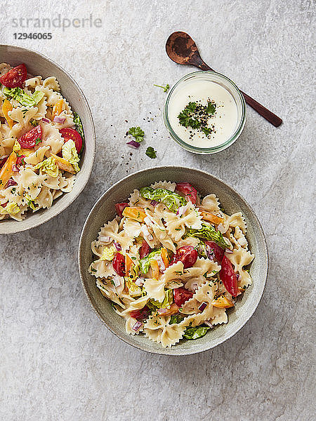 Farfalle-Salat mit Tomaten  Paprika  Petersilie  Zwiebeln und einem Joghurt-Dressing