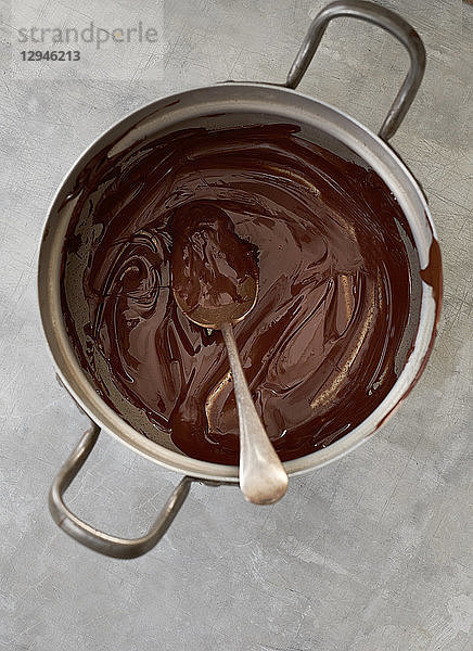 Geschmolzene Schokoladenkuvertüre in einem Topf (Draufsicht)