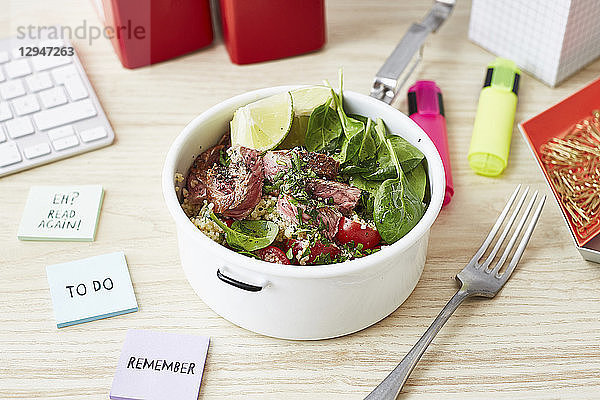 Eine Steakschale mit Spinat für ein Mittagessen im Büro