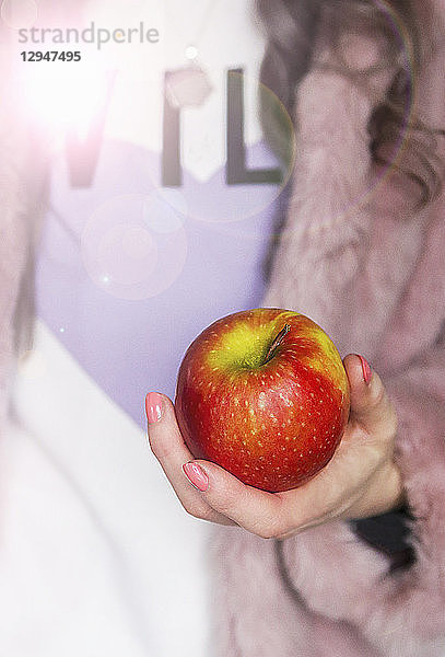 Roter und grüner Apfel in der Hand einer Frau