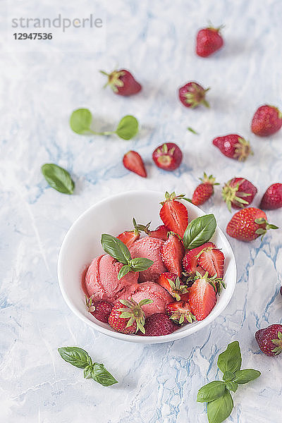 Erdbeereis mit frischen Erdbeeren und Basilikum