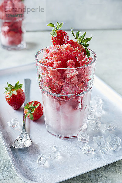 Erdbeergranita in einem Cocktailglas mit frischen Erdbeeren und Eiswürfeln