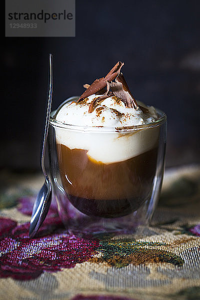 Ein Glas Kaffee mit Sahne und Schokolade