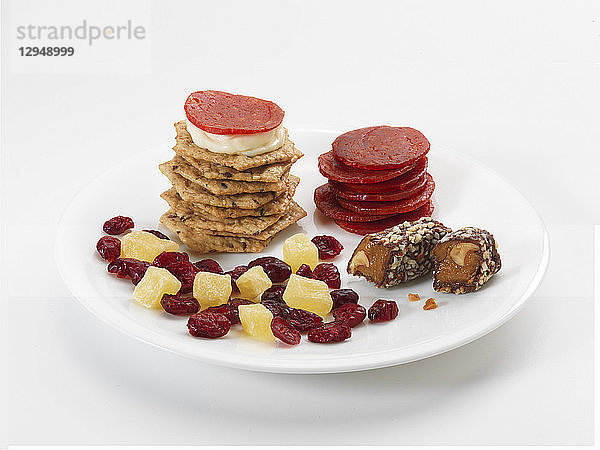 Süße und herzhafte Snacks auf Tellern: Cracker  Würstchen  Trockenfrüchte und Süßigkeiten