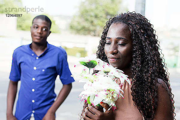 Diese junge Frau mit geschlossenen Augen nimmt ihren Blumenstrauß mit Freude und Liebe entgegen.