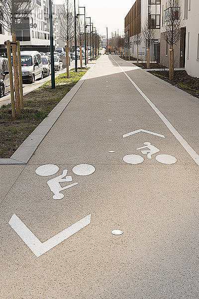Schilder auf dem Boden des Bürgersteigs für Fahrräder in einem neuen Gebiet