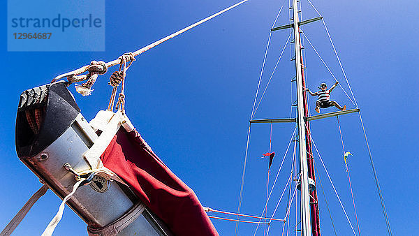 Ein Kind  7 Jahre alt  klettert auf den Mast eines Segelbootes  Clifton  Union Island  Kleine Antillen  Westindische Inseln