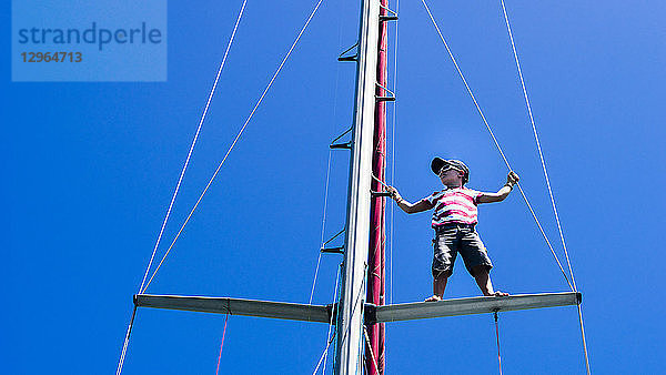 Ein Kind  7 Jahre alt  klettert auf den Mast eines Segelbootes  Clifton  Union Island  Kleine Antillen  Westindische Inseln